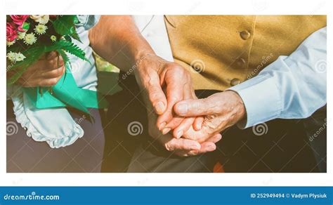 Pareja de ancianos dándose la mano en un banco de parque