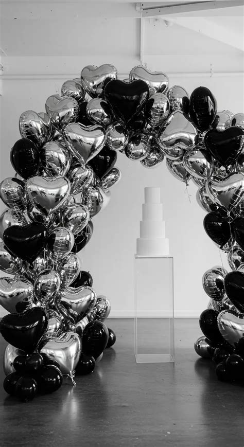 Fotografía de un arco de globos metálicos y guirnaldas de papel hechas a mano.