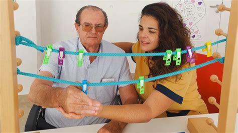 Imagen de personas mayores realizando ejercicios de motricidad fina con cuentas.