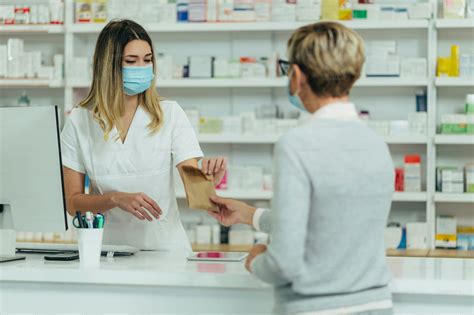 Foto de farmacéutico explicando un medicamento a un cuidador