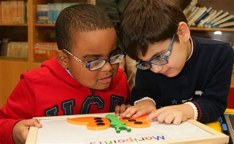 Foto de un niño con discapacidad visual explorando un libro táctil con su padre