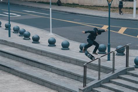 Patinador realizando un truco en un entorno urbano, usando protecciones