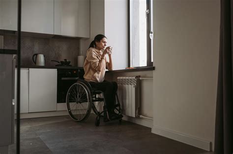 Fotografía de un cuidador agotado bebiendo café mientras mira por la ventana