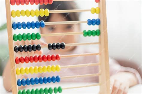 Niño usando cuentas de colores para una operación de suma