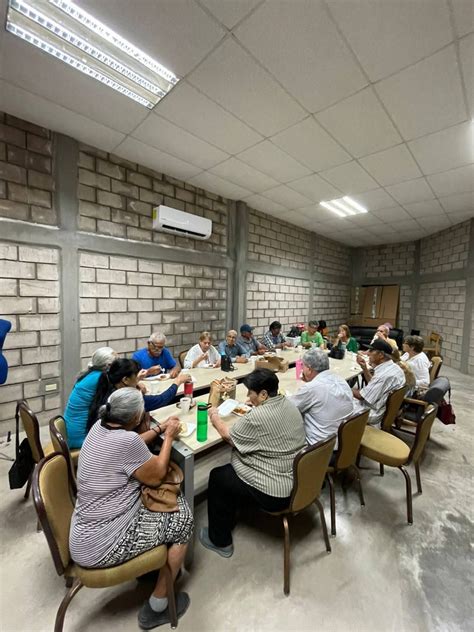 Mesa redonda con adultos mayores interactuando en un centro de día