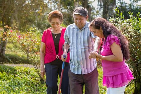 Familiar acompañando a una persona mayor en una caminata por un parque