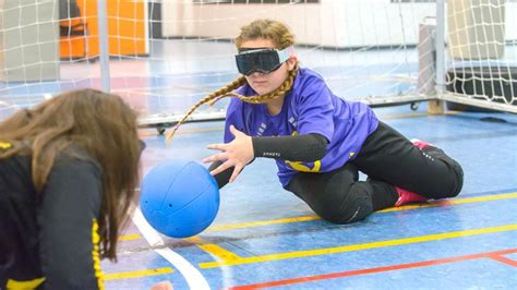 Niños jugando goalball en un polideportivo