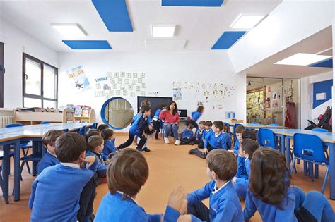 Foto de niños en un aula inclusiva, uno de ellos interactuando con materiales táctiles
