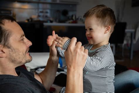 Padre e hijo con discapacidad intelectual poniendo la mesa, mostrando un paso a la vez