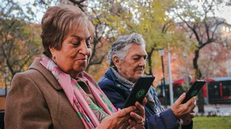 Adultos mayores utilizando teléfonos celulares para conectarse a actividades remotas