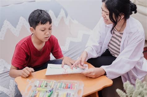 Foto de un terapeuta trabajando con un niño en un ejercicio de lectura