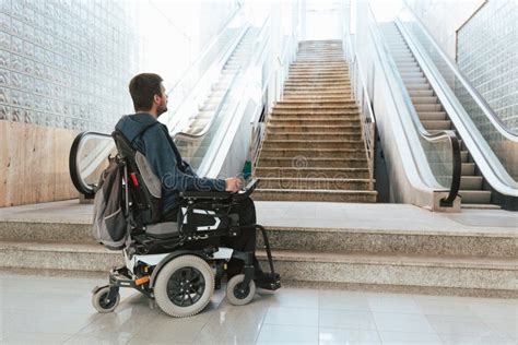 Foto de persona en silla de ruedas intentando superar un obstáculo urbano