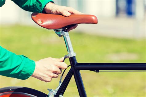 Mujer mayor ajustando el sillín de su bicicleta antes de salir