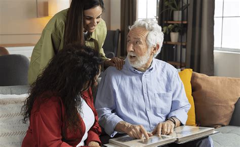 Foto temática: persona mayor con Alzheimer interactuando con su cuidador, en un ambiente cálido y seguro