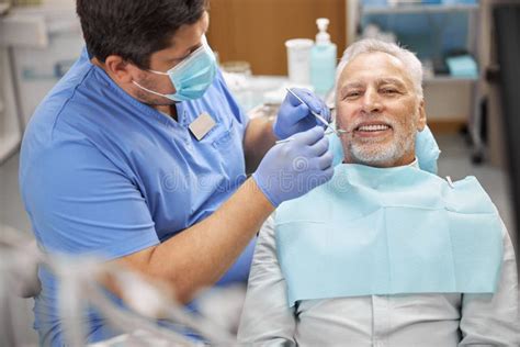 fotografía de consulta dental con dentista examinando a un adulto mayor