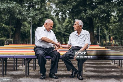 Fotografía de dos adultos mayores conversando y caminando por una calle de Arica.