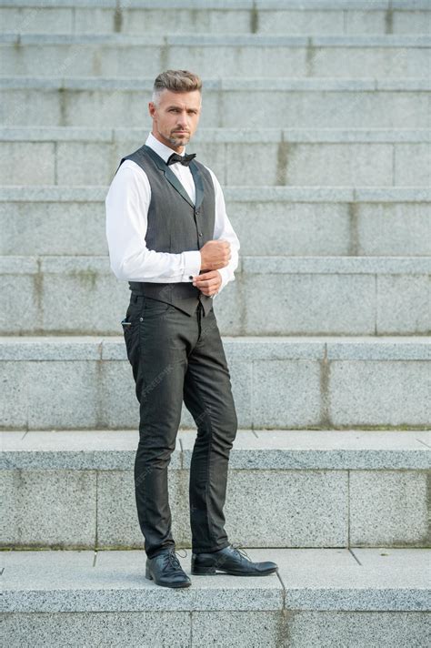 Fotografía de un adulto mayor sonriendo, vestido con ropa moderna y elegante