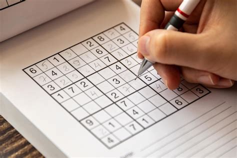 Persona mayor resolviendo un sudoku con concentración