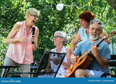 Grupo de adultos mayores tocando instrumentos de percusión y riendo