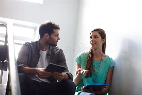Dos adultos conversando en un salón mientras un niño juega en segundo plano, simulando una entrevista con un cuidador