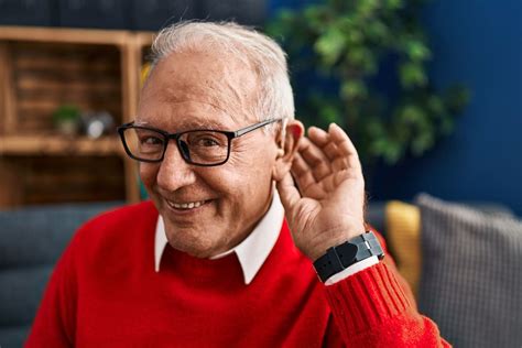 Persona mayor usando audífonos en una conversación