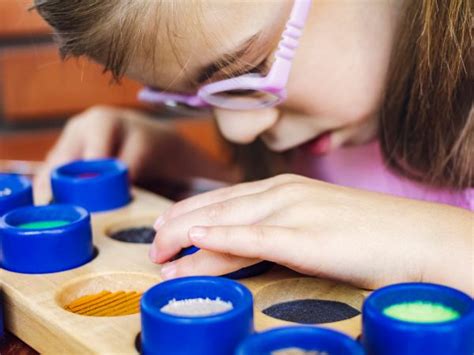 Fotografía de un niño con discapacidad visual explorando un objeto con sus manos.