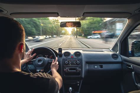 Persona con audífonos conduciendo un coche, mirando espejos