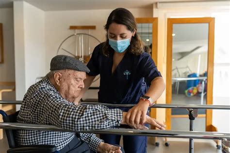 Equipo de cuidadores profesionales asistiendo a un adulto mayor en actividades diarias en un hogar de ancianos