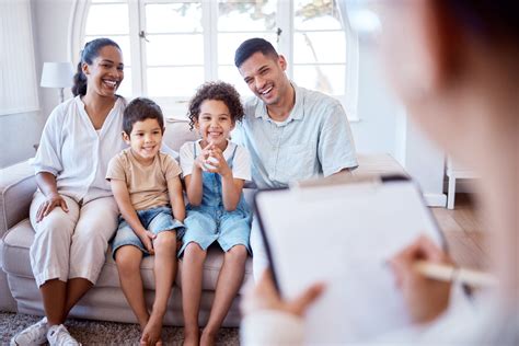 Trabajadora social interactuando con una familia en su hogar, recopilando información