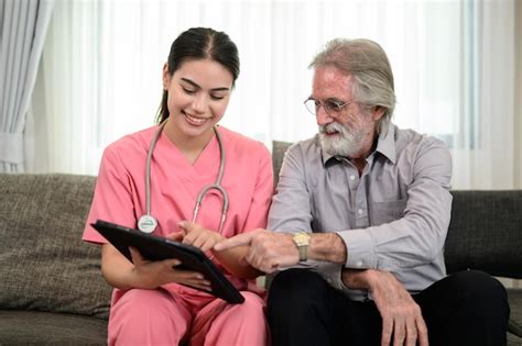 Foto de un médico visitando a un paciente mayor en su casa, con un familiar presente