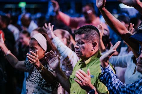 Congregación cantando con alegría y levantando las manos