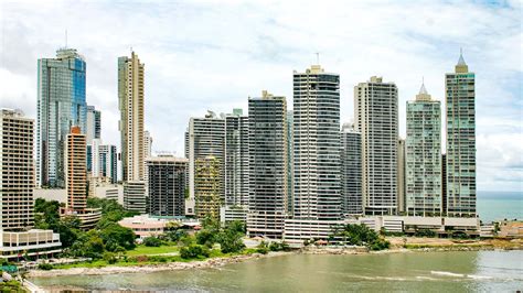Panorama de la ciudad de Panamá al atardecer, con edificios modernos y el océano de fondo, simbolizando un destino ideal para jubilados.