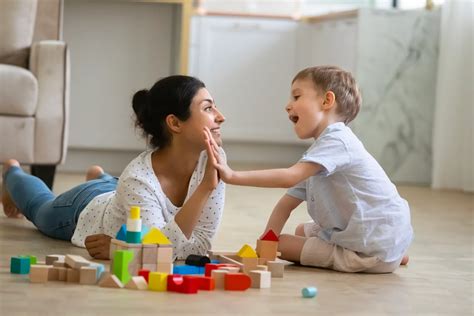 Foto temática de una niñera interactuando felizmente con niños pequeños en un ambiente seguro y luminoso