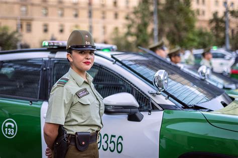 Foto de Carabineros de Chile en una protesta, con manifestantes de fondo.