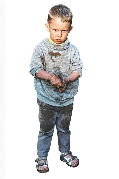 Foto de un niño pequeño descalzo y sucio en un ambiente de taller mecánico