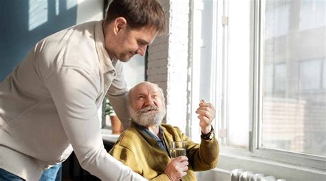 Foto temática: cuidador de ancianos ayudando con la medicación y tareas domésticas