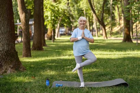 Grupo de adultos mayores practicando yoga en silla en un parque