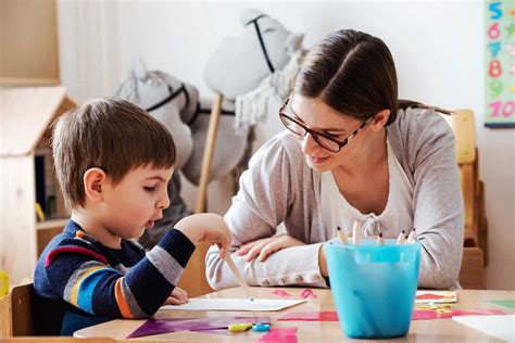 fotografía de un cuidador interactuando con un niño en casa en un entorno de juego o aprendizaje