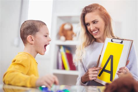 Niño realizando ejercicios de logopedia con un terapeuta