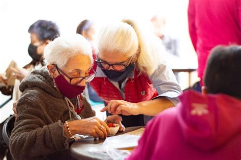 Grupo de adultos mayores participando en actividades de estimulación cognitiva y ejercicios ligeros en un taller comunitario.
