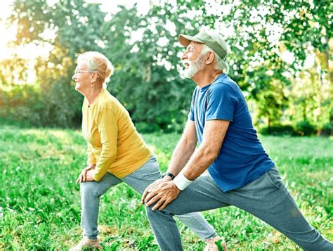 Adultos mayores sonriendo y socializando mientras caminan en un parque