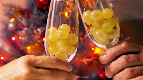 Fotografía de copas de mimosas con uvas congeladas y burbujas.