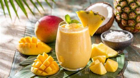 Imagen de un smoothie de mango y piña en un vaso alto.