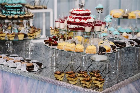 Foto de una mesa de buffet con postres y dulces presentados a diferentes alturas