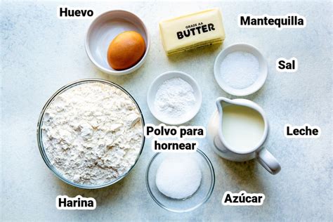 Foto de un bol con ingredientes secos y líquidos para panqueques, con un batidor de mano