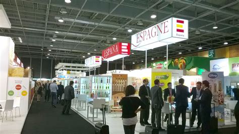 Foto de una feria comercial con stands y asistentes interactuando