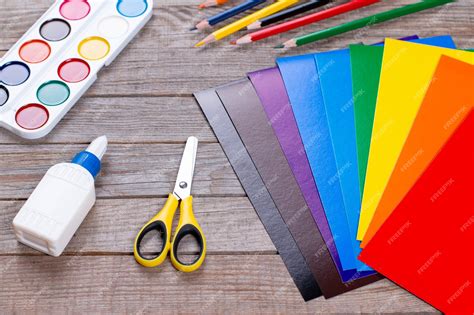Una mesa de trabajo con materiales variados para manualidades: lanas de colores, tijeras, pegamento, cartulinas, etc.