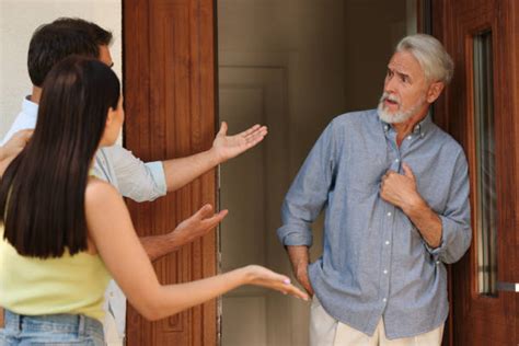 Foto de una puerta de casa con vecinos preocupados fuera