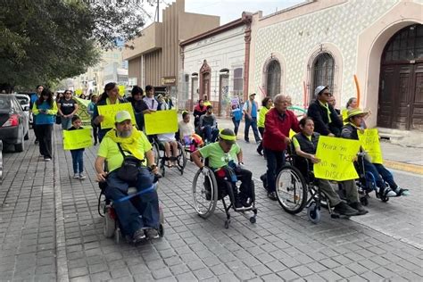 Fotografía de personas participando activamente en una marcha por la discapacidad con carteles