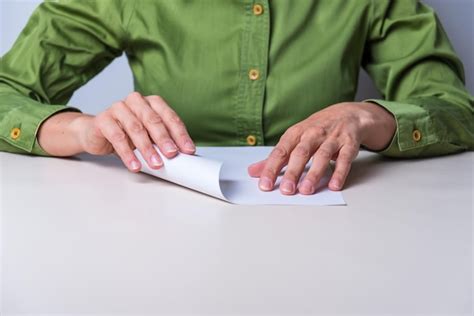 Persona mayor doblando papel de origami con concentración